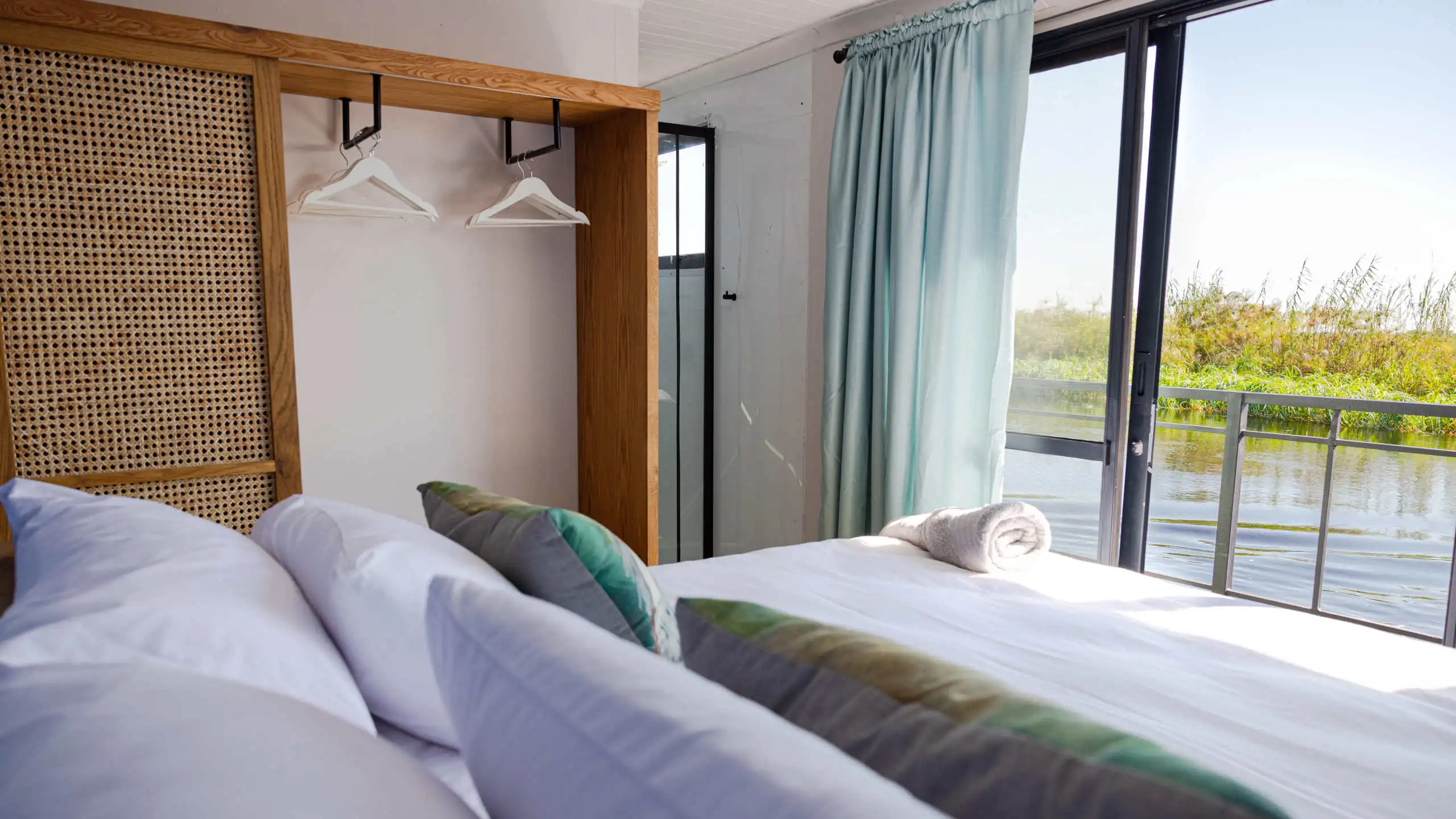Comfortable and stylish cabin on the Ngwezi Houseboat, offering stunning views of the Okavango Delta from the spacious windows, with soft linens and modern amenities for a relaxing stay.