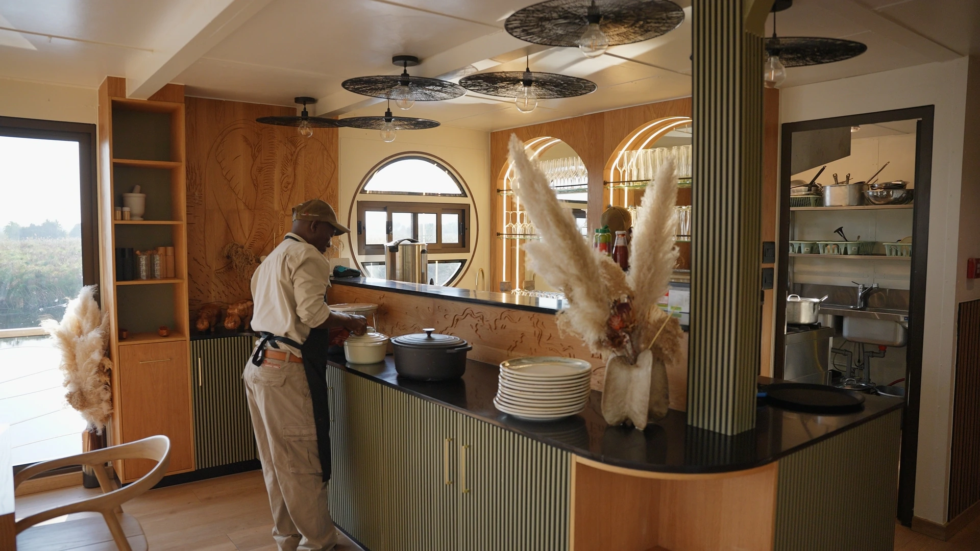 Crew member preparing drinks at the bar of the Okavango Endeavour