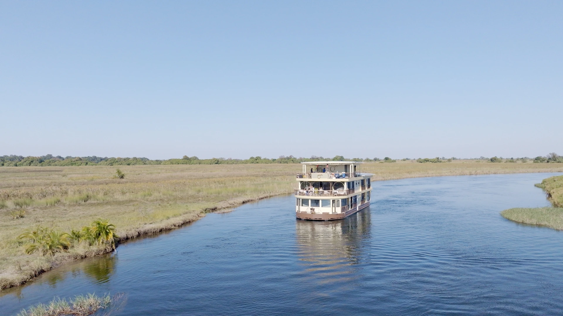 The Okavango Endeavour houseboat cruising a channel of the Okavango Delta