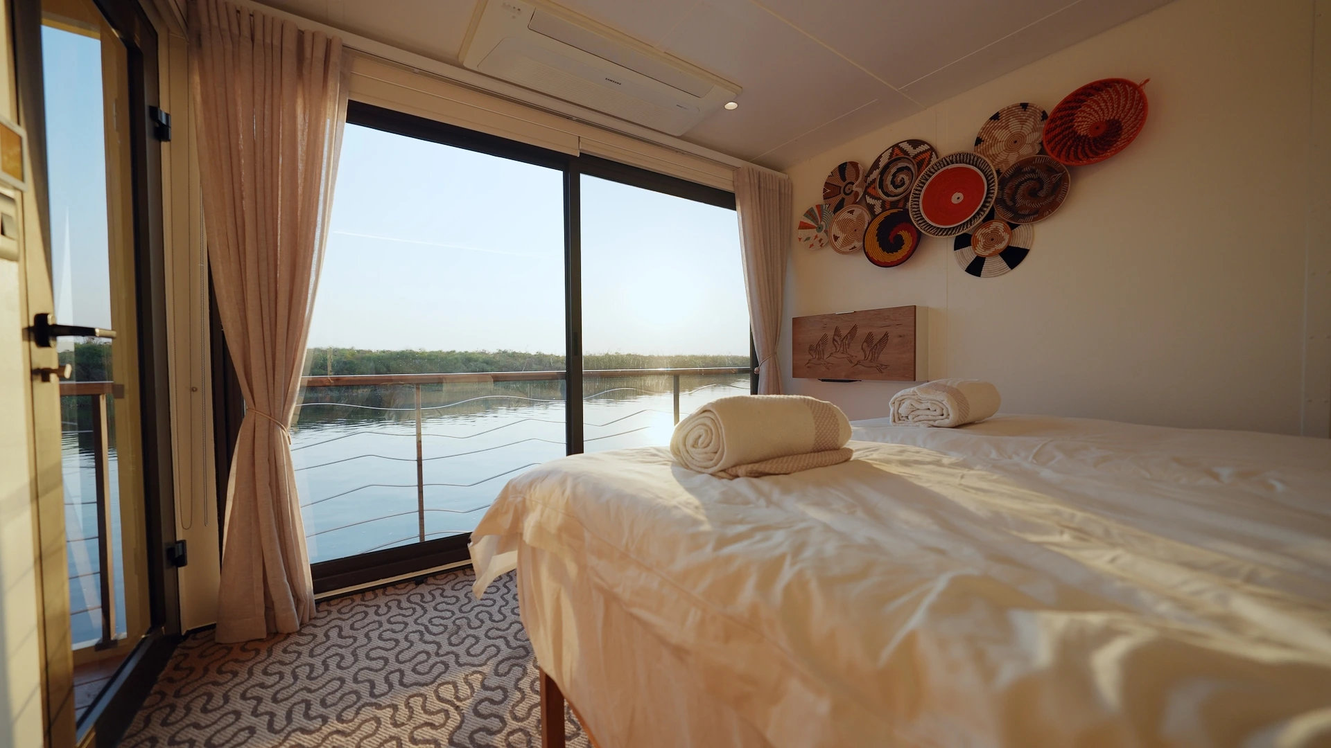 Guest cabin aboard the Okavango Endeavour with floor-to-ceiling windows over the water