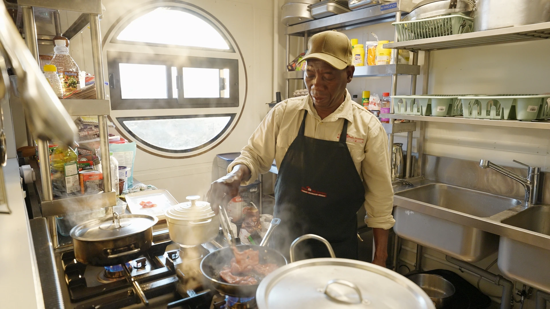 Chef preparing a meal in the galley kitchen of the Okavango Endeavour