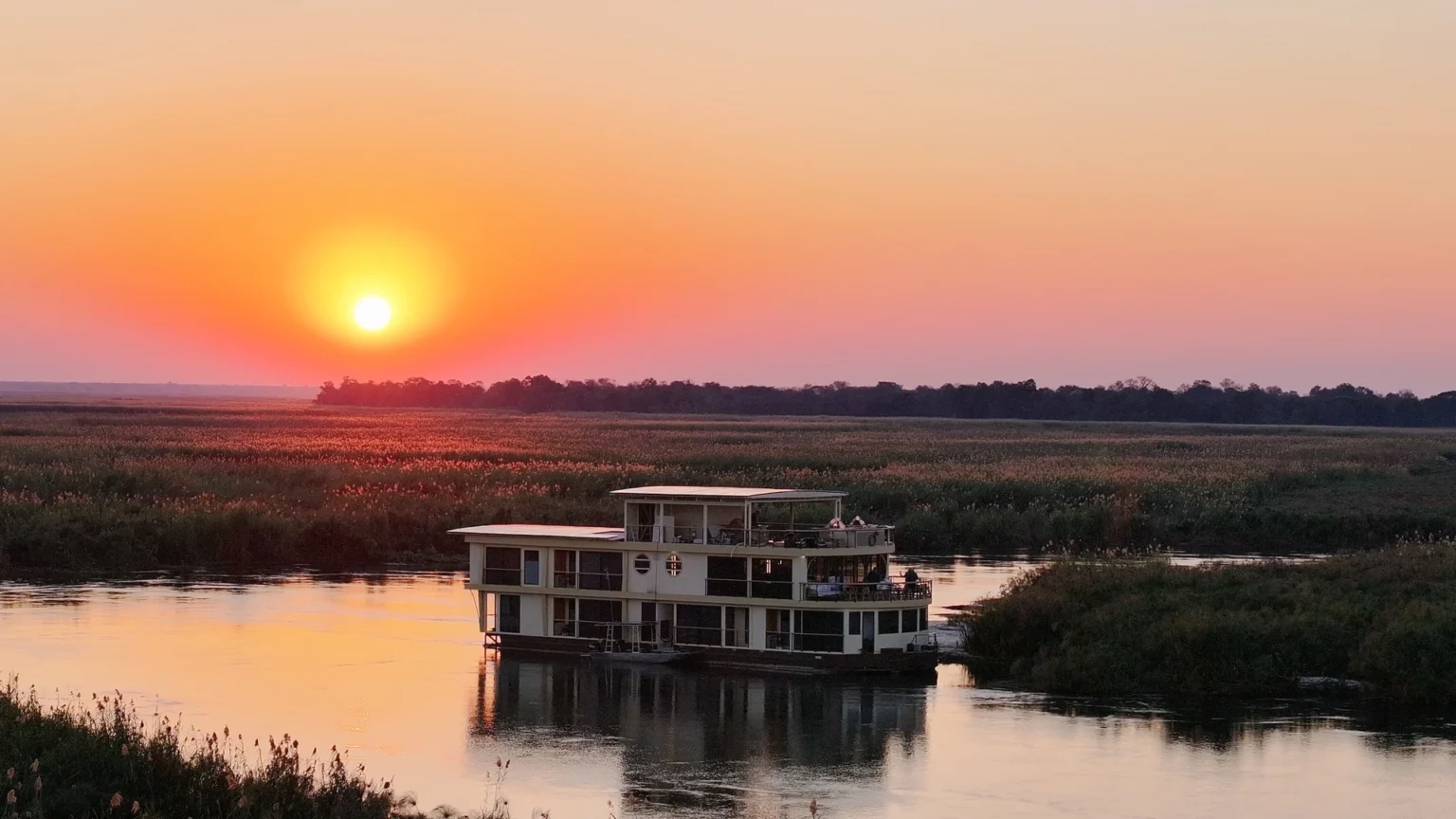 Sunset over the Okavango Delta floodplain with the Endeavour moored in the distance